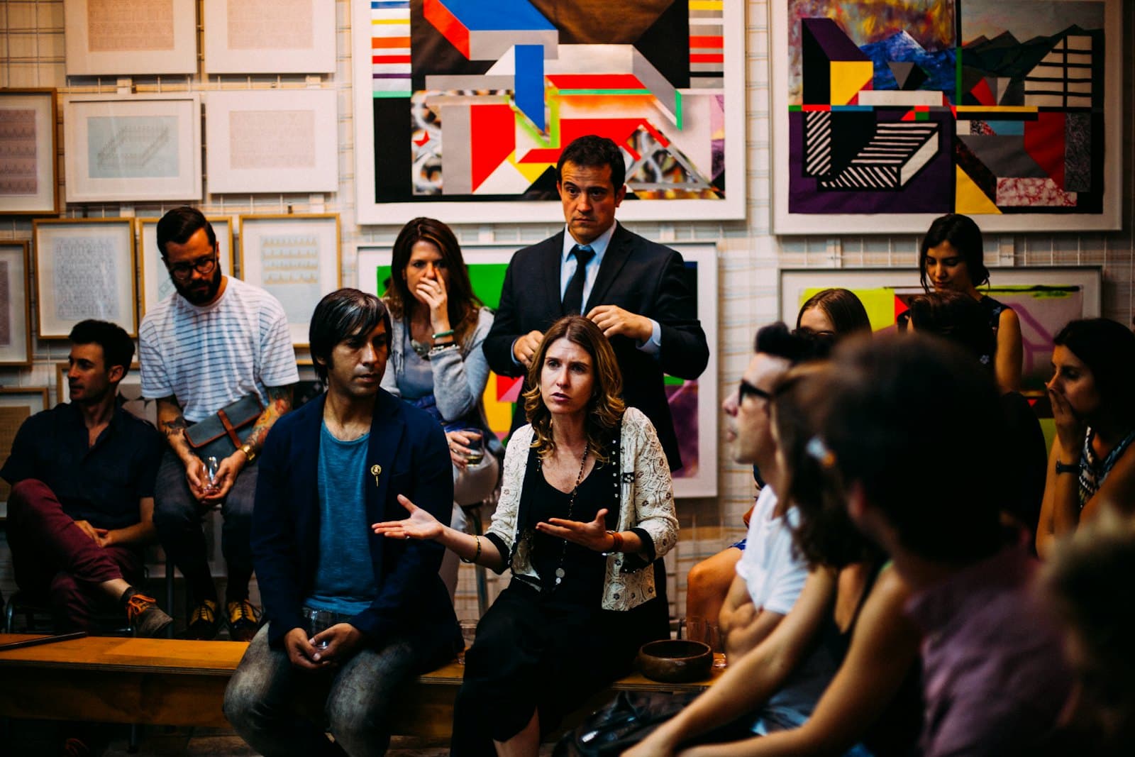 A diverse group gathered in a classroom, listening as one person speaks.