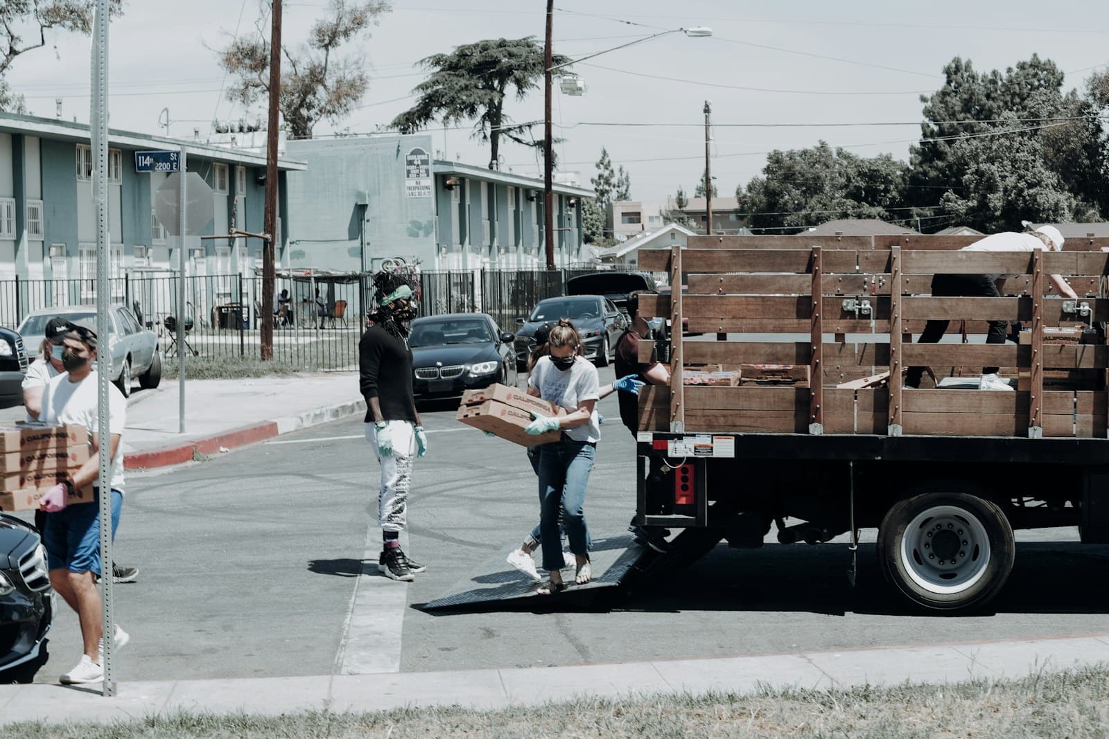 Volunteers unloading boxes from a delivery truck on a residential street.